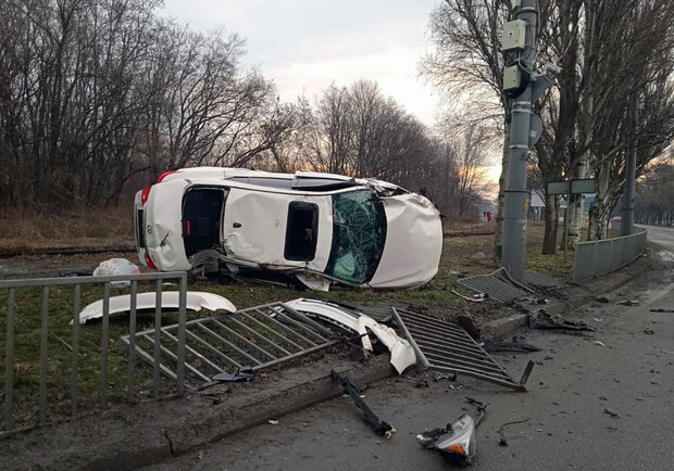 На Запорожском шоссе "Инфинити" снесла забор и перевернулась - фото: ГСЧС