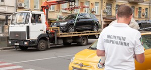 Залезла на эвакуатор: на Подоле женщина не давала эвакуировать свой автомобиль
