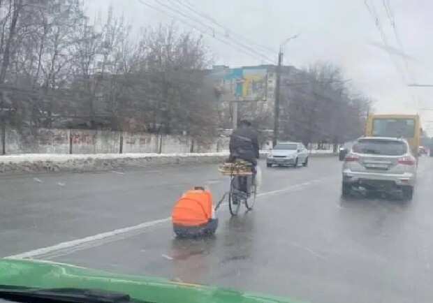 На улицах Днепра ездит мужчина с "прицепом" 