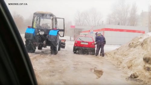 Водитель снегоуборочной машины сливает топливо таксисту. фото: www.mnenie.dp.ua