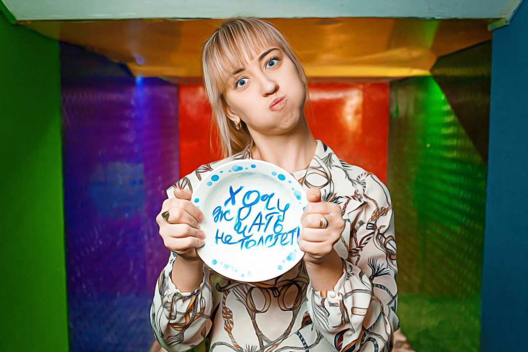 Девушка собирается разбить тарелку в антистрессовой комнате/ фото: go-go.ua