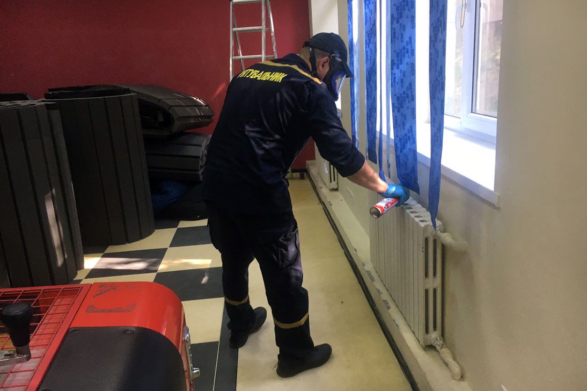 Спасатель обрабатывает аэрозолем место, где поселились осы/ фото: пресс-служба ГСЧС