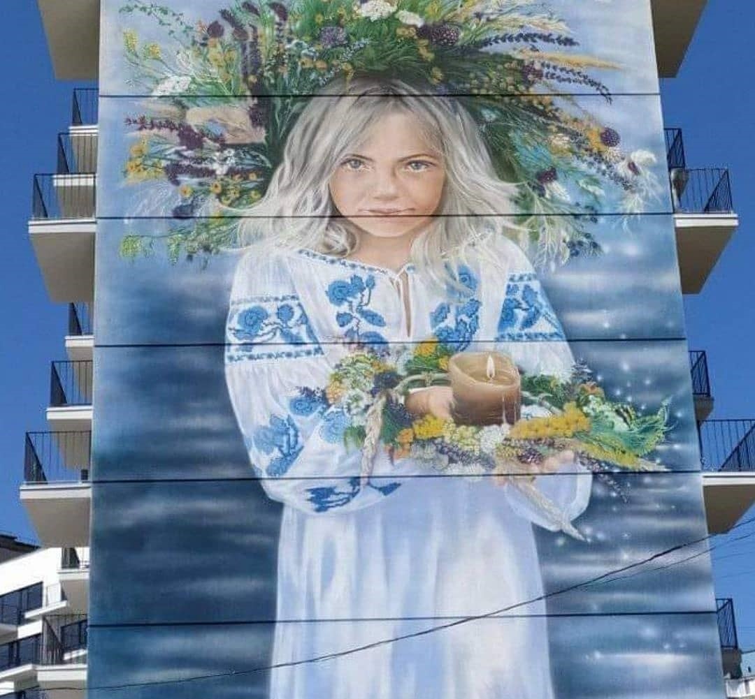 Маленька українка, яка тримає вінок із польових квітів на святі Івана Купала